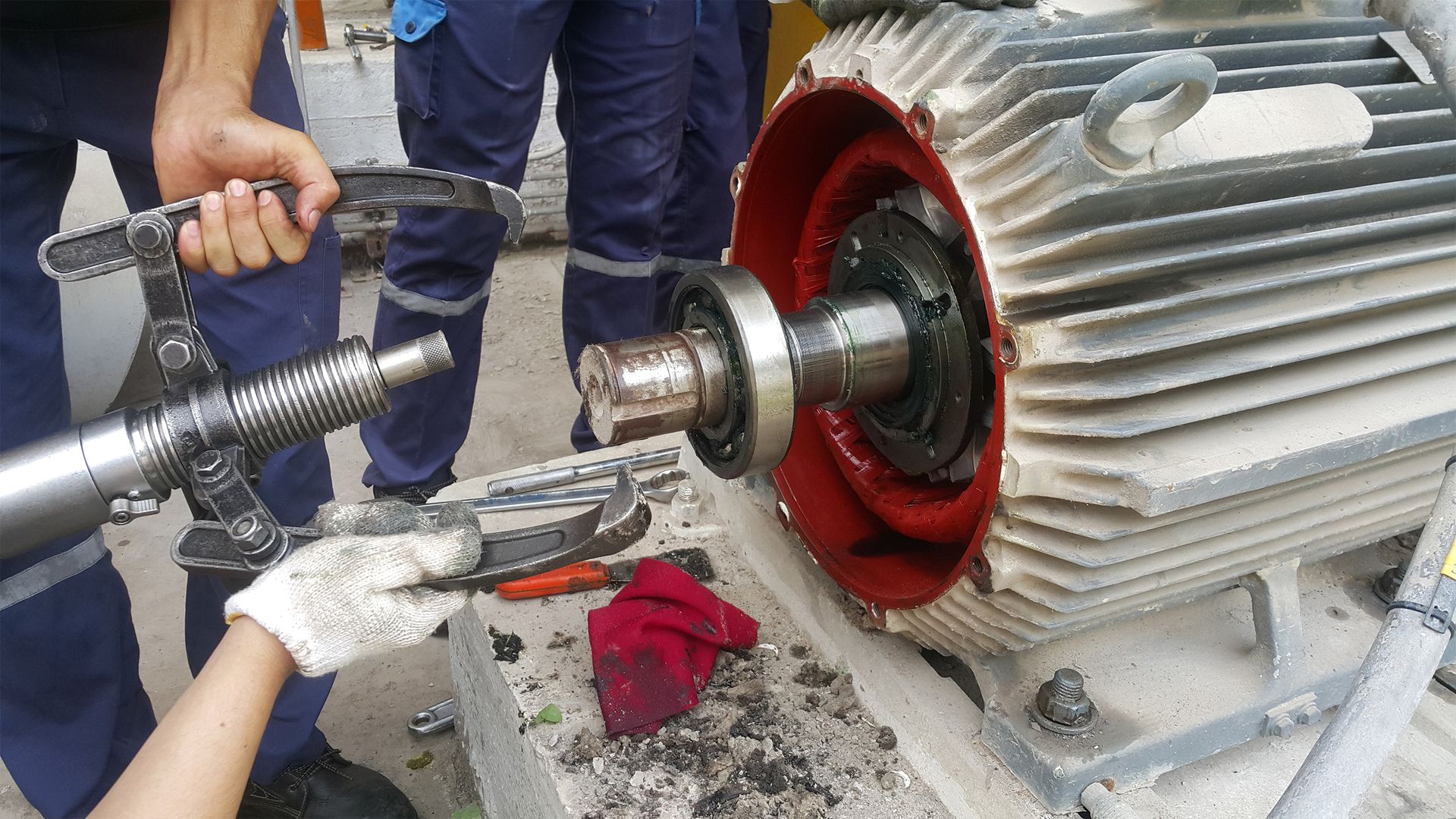 A man operates a large industrial machine, focused on his task in a well-lit workshop environment.